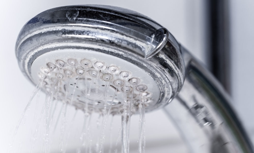 Ein verkalkter Duschkopf, der auf eine geringe Wasserqualität oder mangelnde Wartung hinweist.