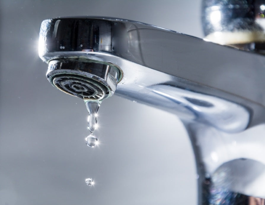 Ein tropfender Wasserhahn, der auf einen undichten Wasserhahn oder eine undichte Armatur hinweist, was zu verschwendetem Wasser und potenziellem finanziellen Verlust führen kann.