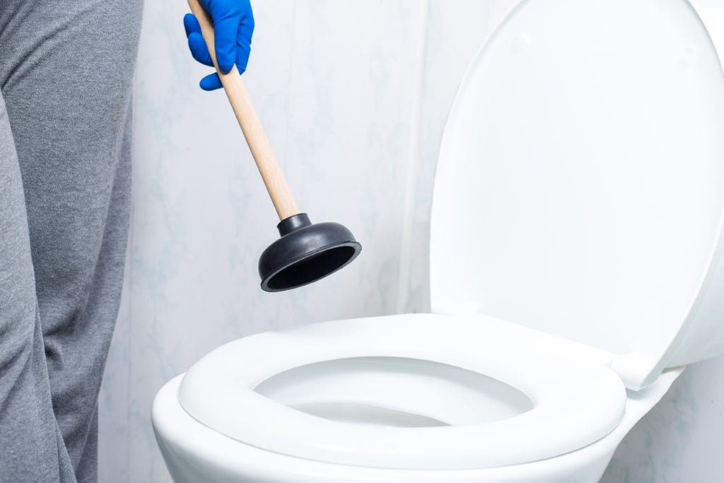 Ein Bild einer verstopften Toilette, bei der das Wasser über den Rand hinausragt, was auf eine Blockade im Abfluss hinweist und eine dringende Reinigung erfordert