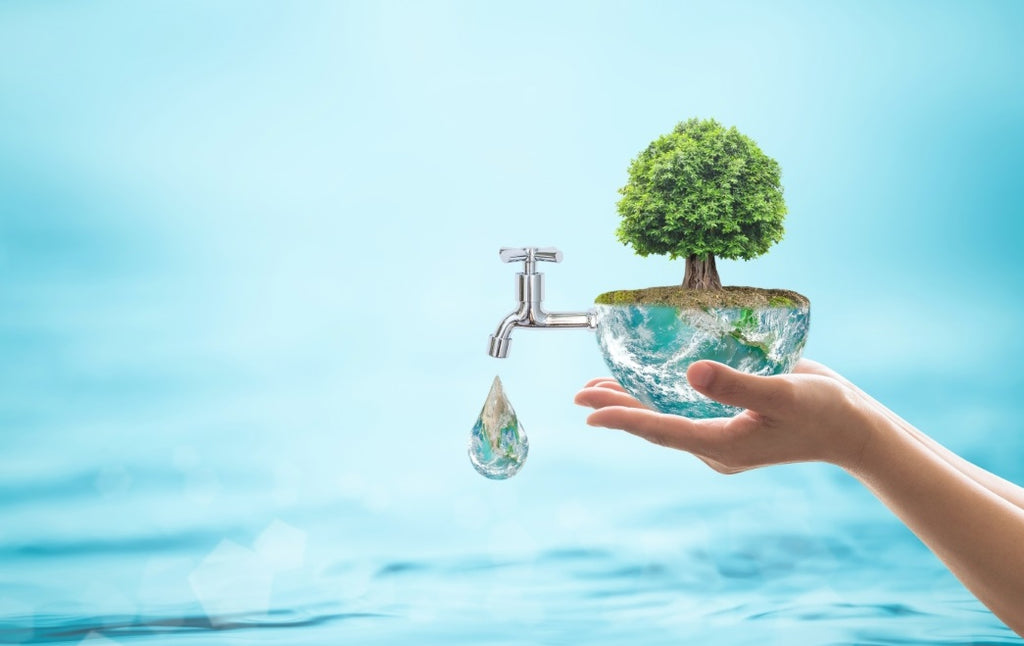 Ein Bild zum Thema Wassersparen: Eine Hand die einen großen Wassertropfen in der Hand hält, aus dem ein Baum wächst und ein Wasserhahn am Tropfen angeschlossen ist.